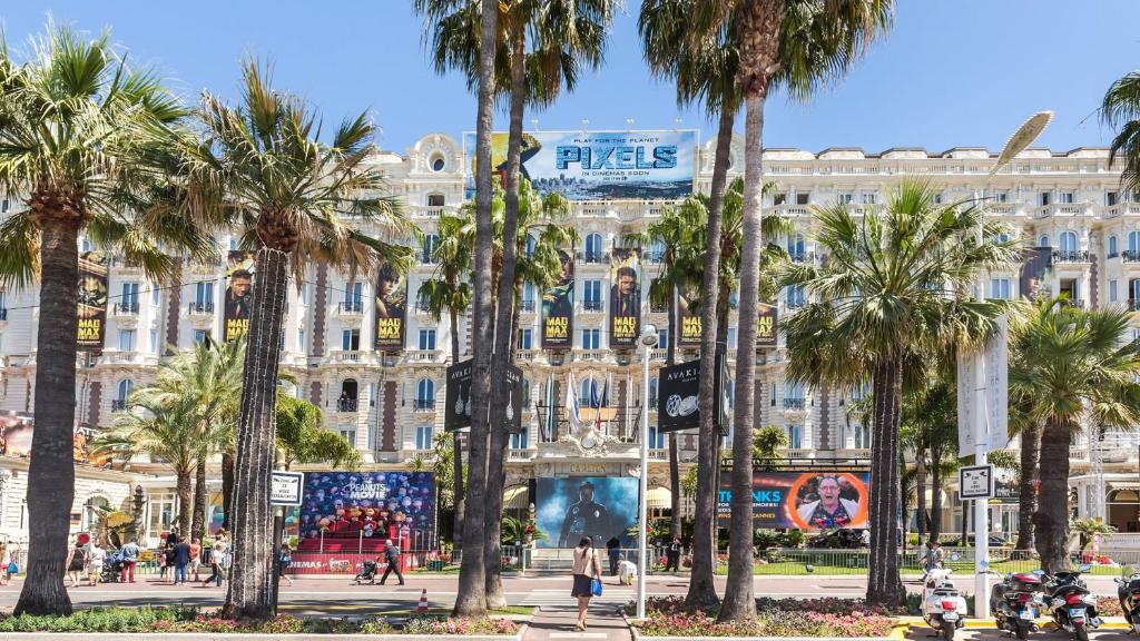 a large building with palm trees in front of it at GRAY 2a6 in Cannes