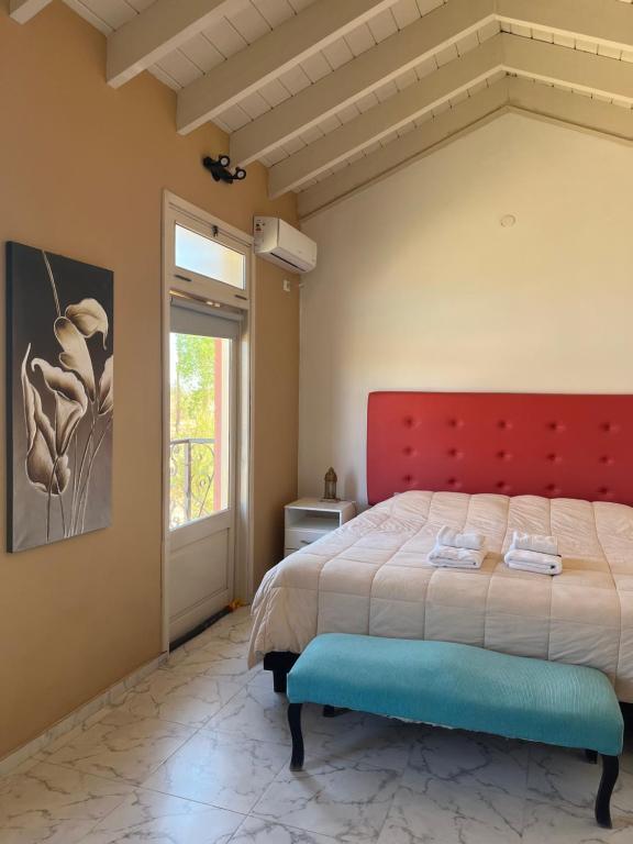 1 dormitorio con 1 cama grande y cabecero rojo en Posada Villa Pituil en Barreal