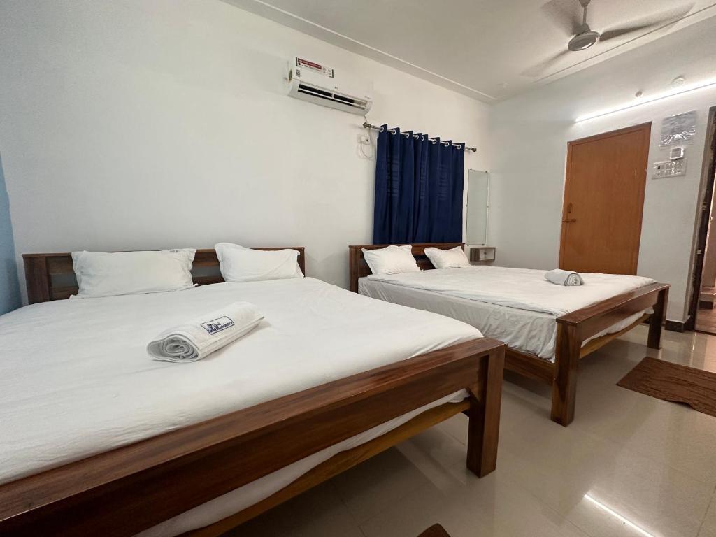 two beds in a small room at MPS Saai Residency in Tiruvannāmalai