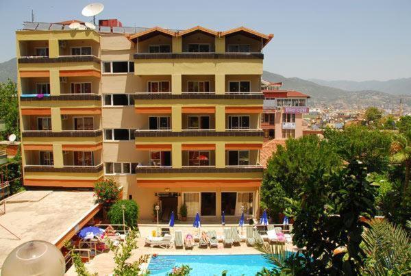 um hotel com piscina em frente a um edifício em Park Hotel em Alanya