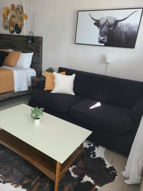 a living room with a couch and a cow on the wall at Modern Studio Retreat with King Bed - Cozy Comfort in Pahokee