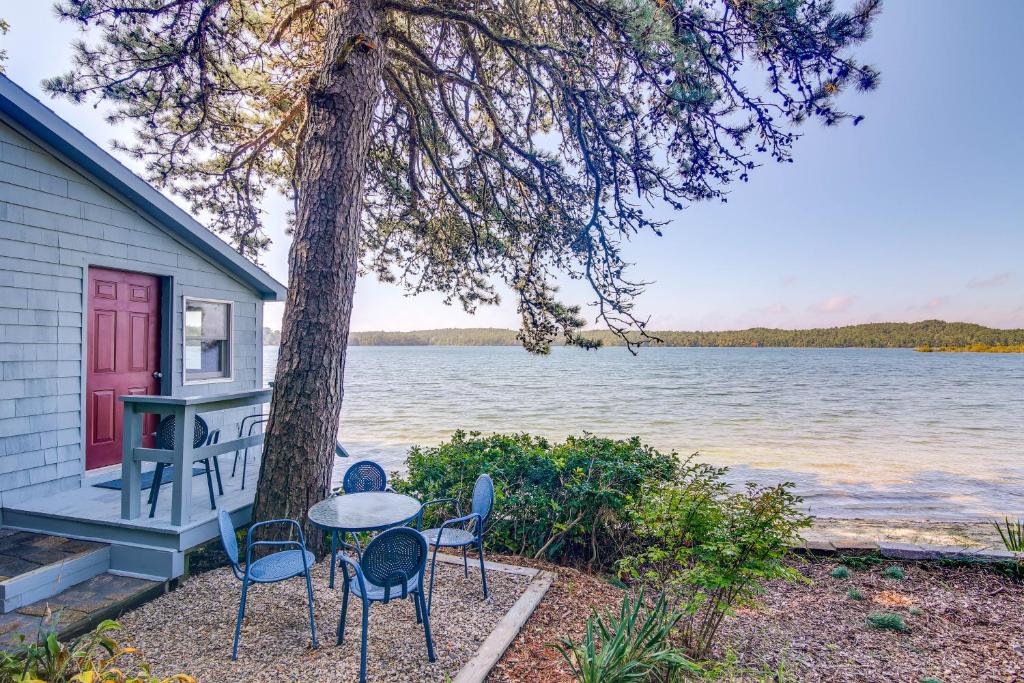 una casa con tavolo e sedie accanto ad un albero di Quiet Plymouth Cottage on Great South Pond! a Plymouth