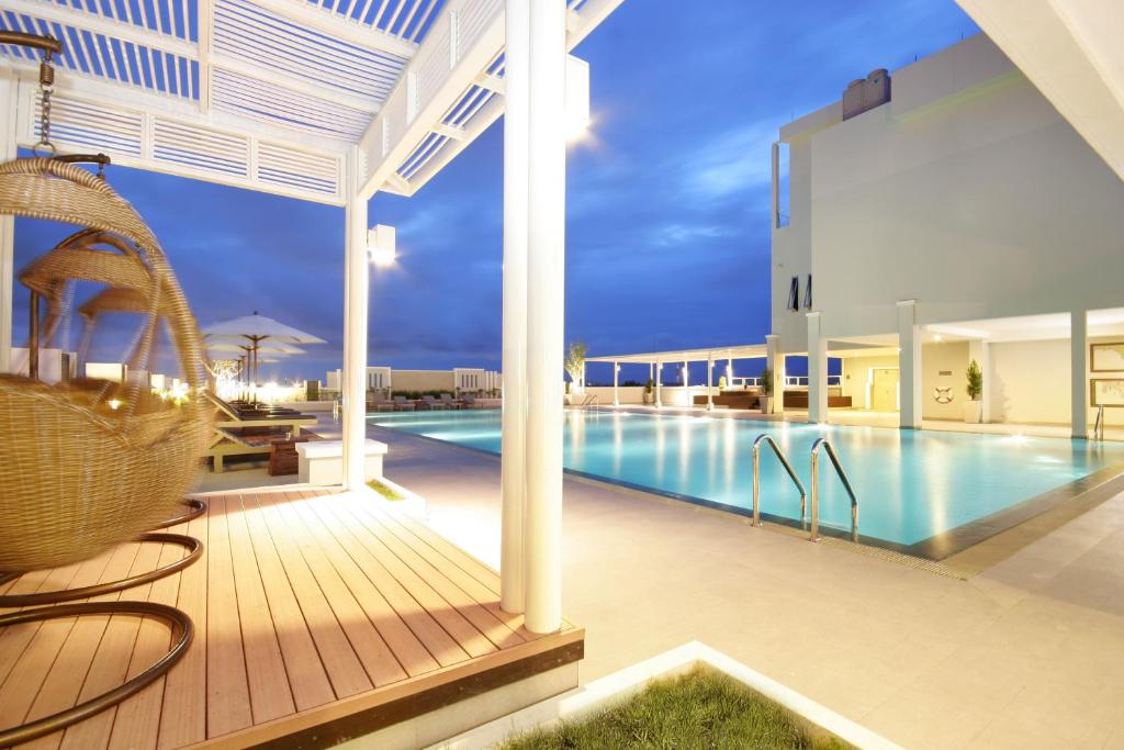 a swimming pool in a villa at night at Kameo Grand Hotel & Serviced Apartment, Rayong in Rayong