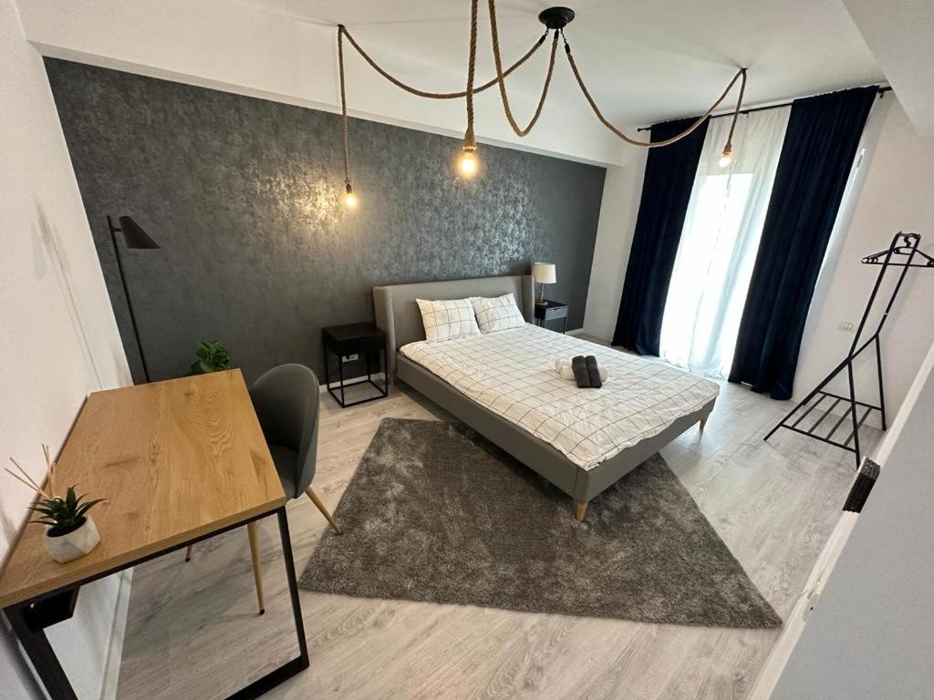 a bedroom with a bed and a table in it at City Center Accommodation - 308 in Reşiţa