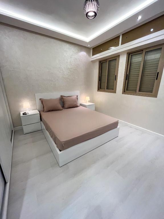 カサブランカにあるL'Appartement Harmonia Cozyのベッドルーム1室(ベッド1台、ナイトスタンド2台付)
