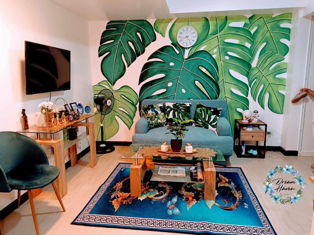 ein Wohnzimmer mit einem blauen Sofa mit einer Uhr an der Wand in der Unterkunft Azure Urban Resort Residence in Manila