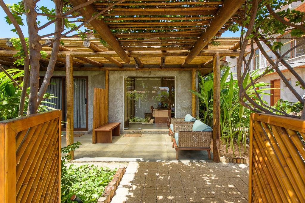 un patio al aire libre con pérgola de madera en Vila Sal Noronha en Fernando de Noronha