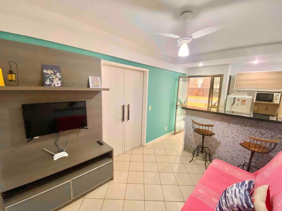 a living room with a pink couch and a kitchen at Ocean Flat 607 in Vila Velha