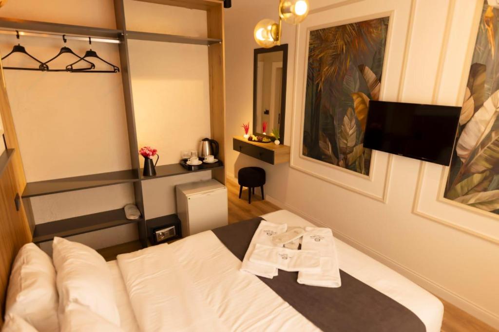 ein Hotelzimmer mit einem Bett und einem TV in der Unterkunft GRAND İŞBİLİR HOTEL in Nevşehir