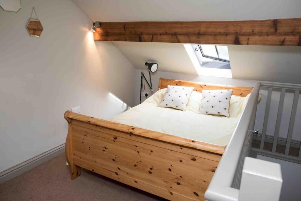 - une chambre mansardée avec un lit en bois dans l'établissement 1700 Period Cottage George Street Addingham, à Addingham