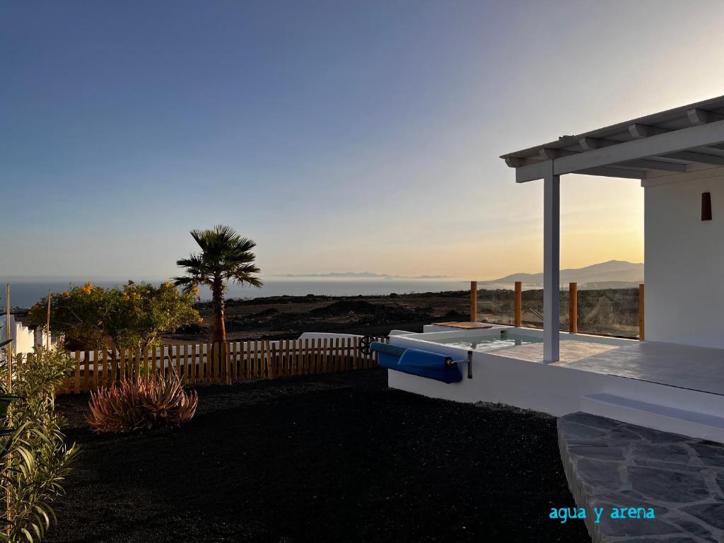 a house with a deck with a view of the ocean at CASA TIE' Lanzarote vista mar - piscina relax - adults only in Tías