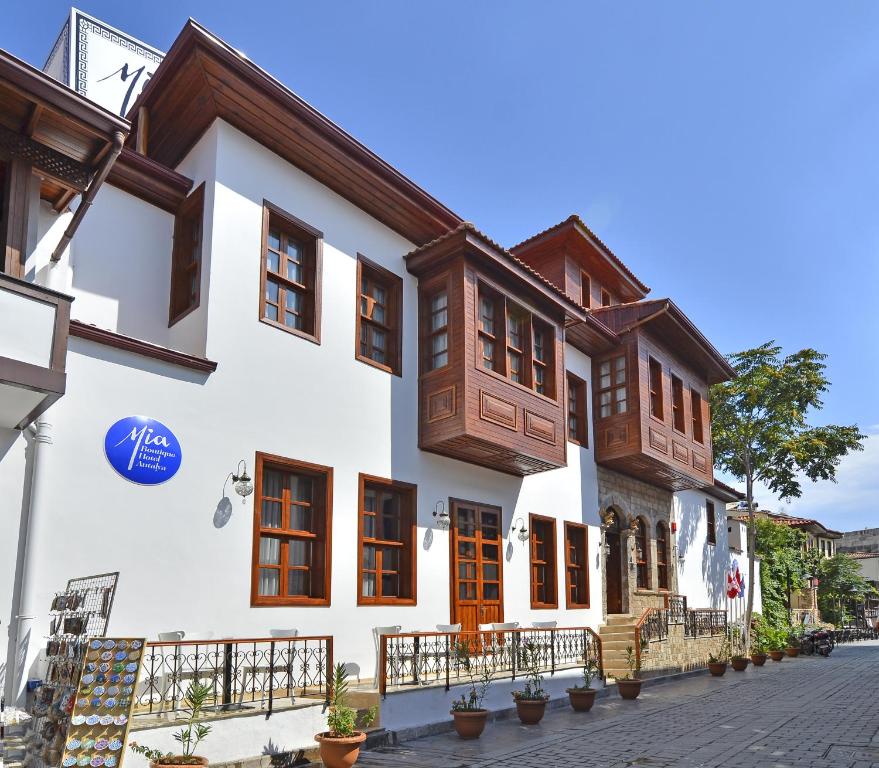 a white building with wooden doors and windows at Mia Hotel in Antalya