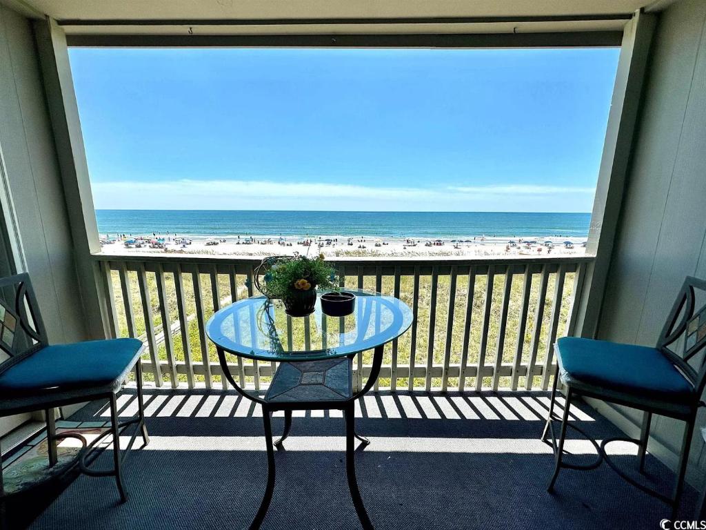 una mesa en un balcón con vistas a la playa en Tequila Sunrise en Myrtle Beach