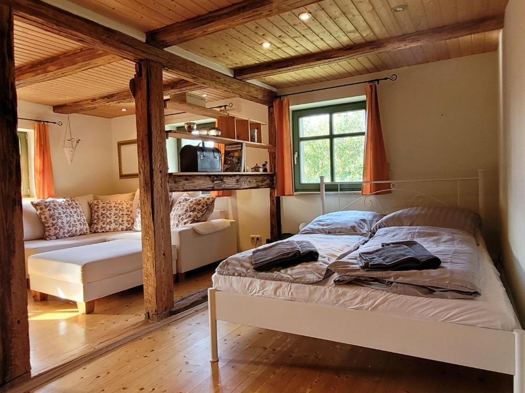 a bedroom with a bed and a couch in a room at Unterkunft am Weinberg in Nünchritz