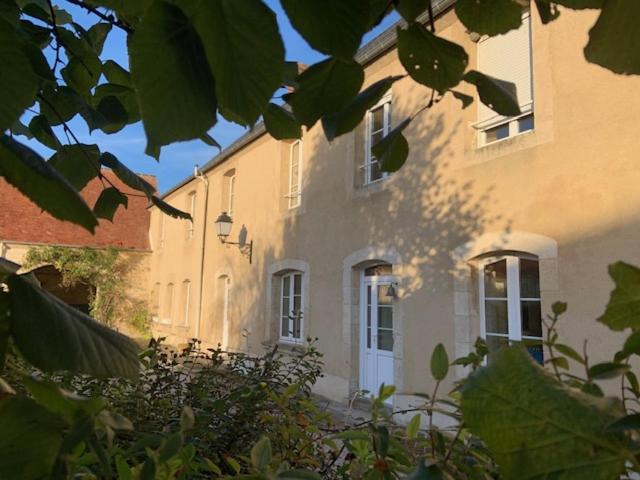 un edificio amarillo con una puerta y ventanas blancas en La Ferme de l'Abbaye, en Silli-en-Gouffern