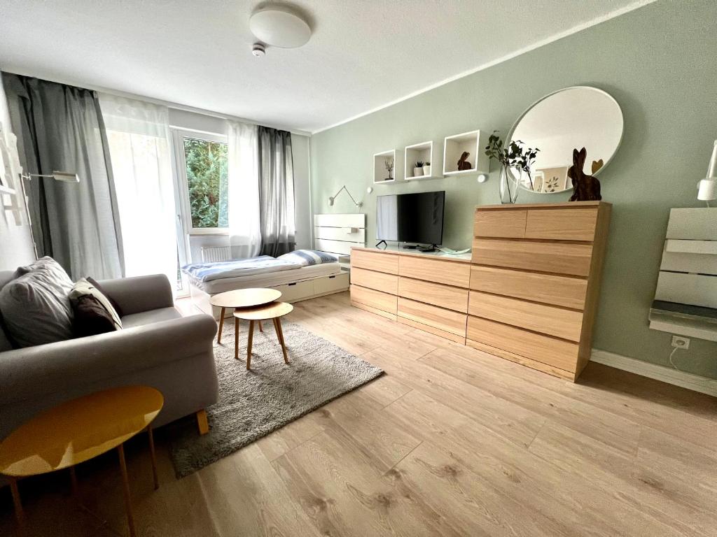 - un salon avec un canapé et un miroir dans l'établissement 1-2 Pers nur 0,3 km zur City von Wuppertal-modern, à Wuppertal