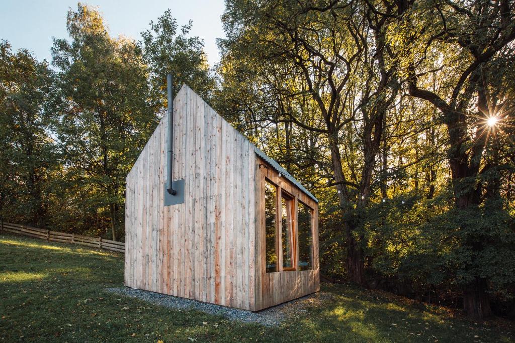 a small wooden house in a field with trees at Na seně in Kozlovice