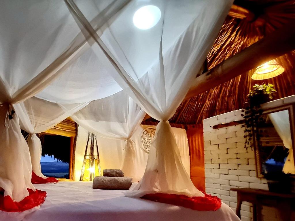 um quarto com uma cama de dossel branco em Recanto das Mels no Alto da Chapada em Alto Paraíso de Goiás