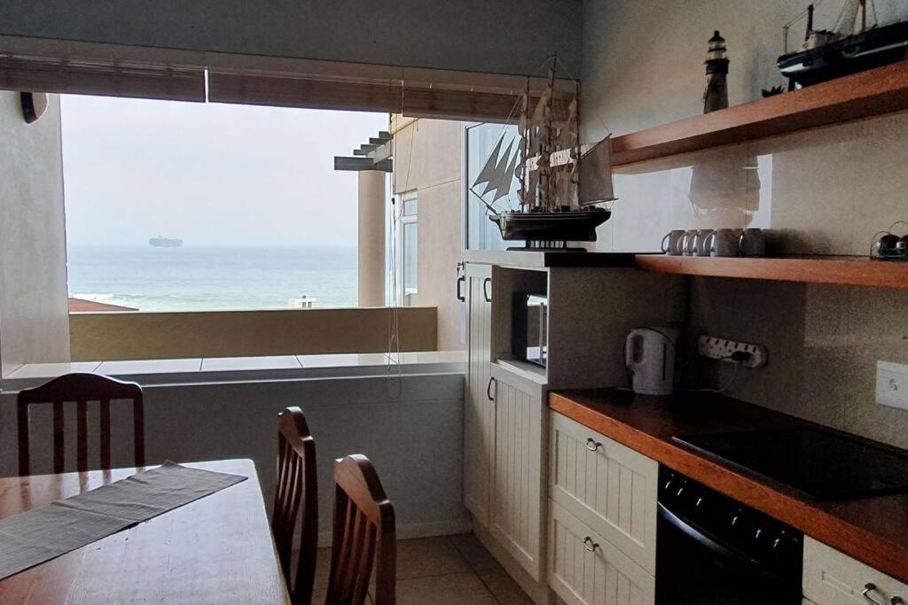 a kitchen with a table and a view of the ocean at CUTTY SARK in Langstrand