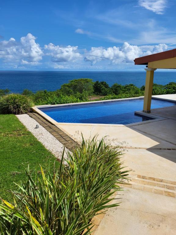 a swimming pool with the ocean in the background at Ballena Bay Villa Lot 45 Villa del Mar in Tambor