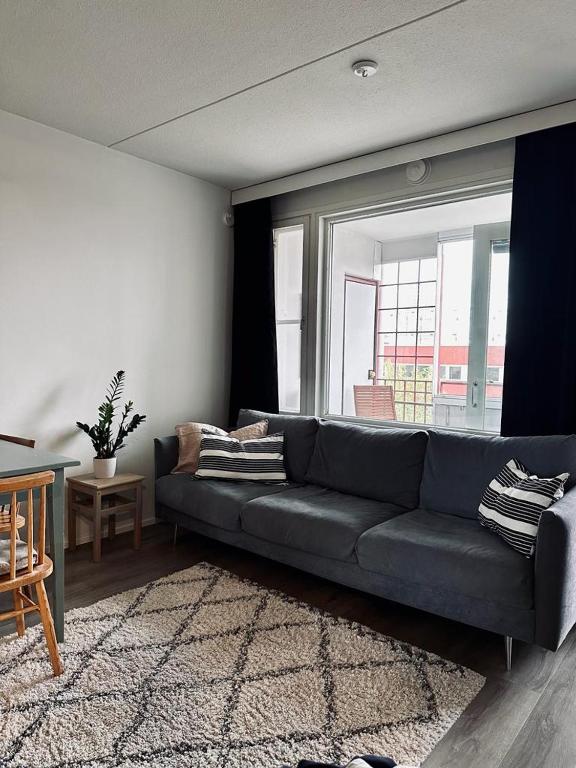 a living room with a blue couch and a window at Moderni yksiö parvekkeella,, erinomainen sijainti in Helsinki