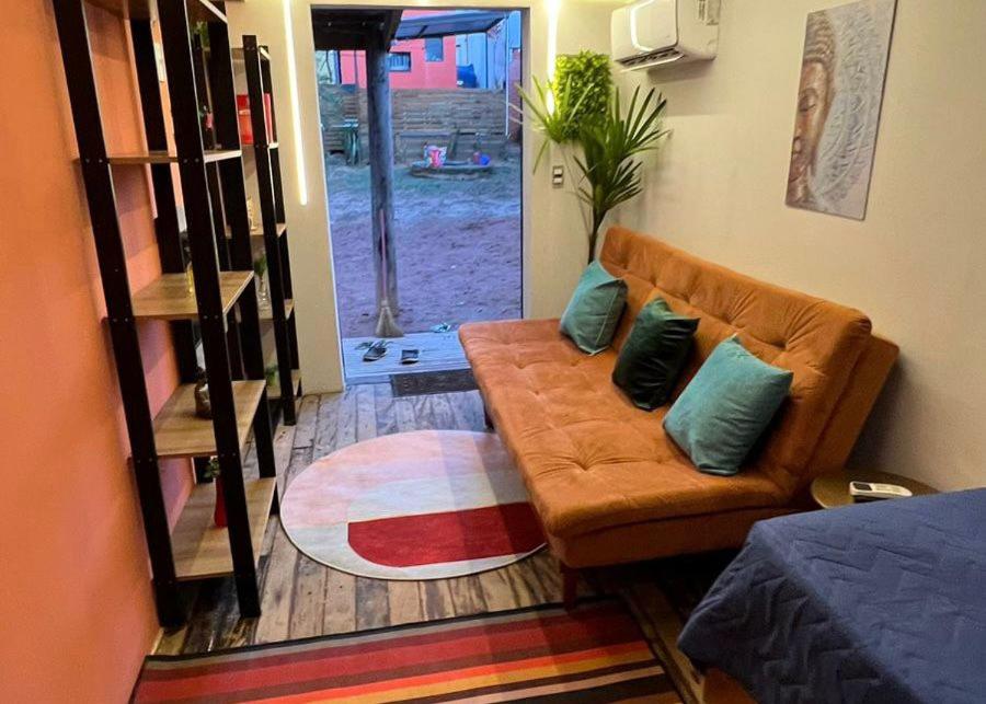 uma sala de estar com um sofá com duas almofadas em Minicasa Brasileira em Sorocaba