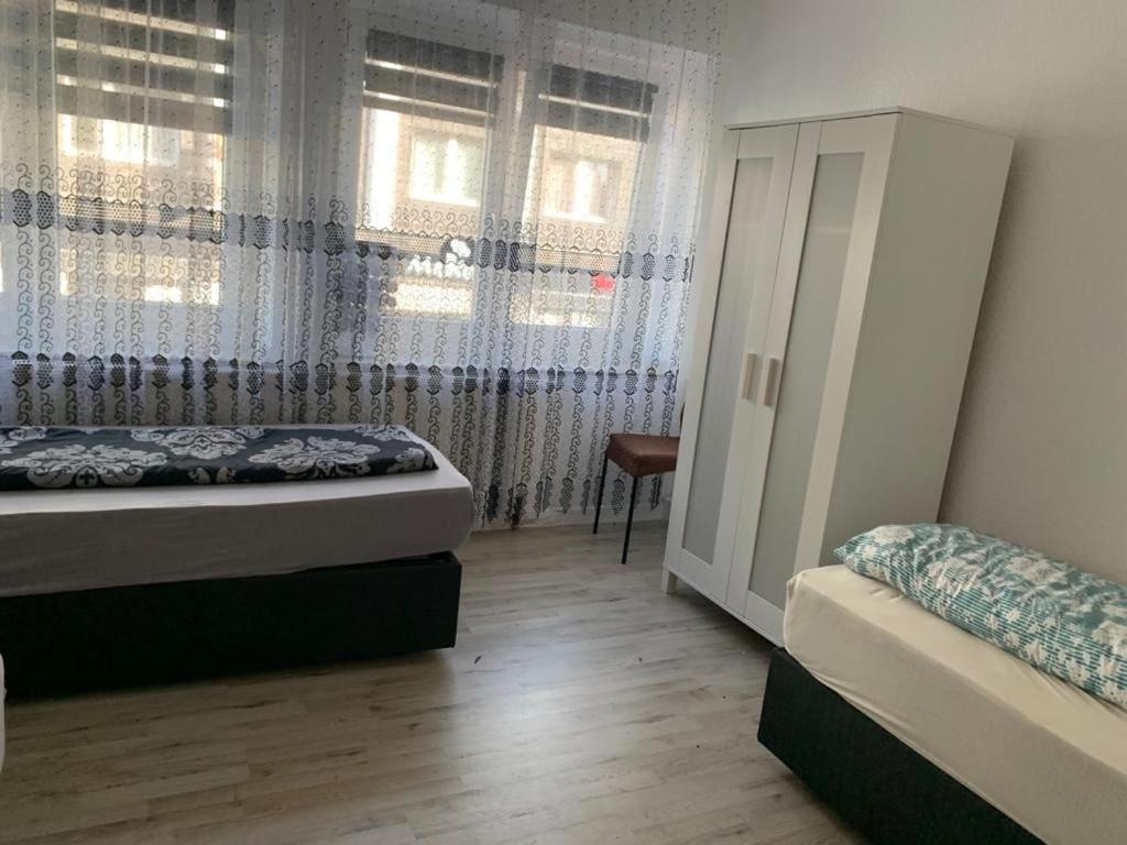 een slaapkamer met een bed en een raam met gordijnen bij Unterkunft Mara in Oberhausen
