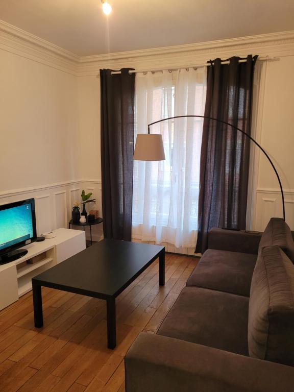 a living room with a couch and a coffee table at L&#39;appartement Idéal 4 voyageurs in Boulogne-Billancourt