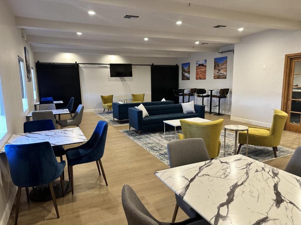 a waiting room with tables and chairs and a couch at Clarion Pointe Winslow I-40 in Winslow