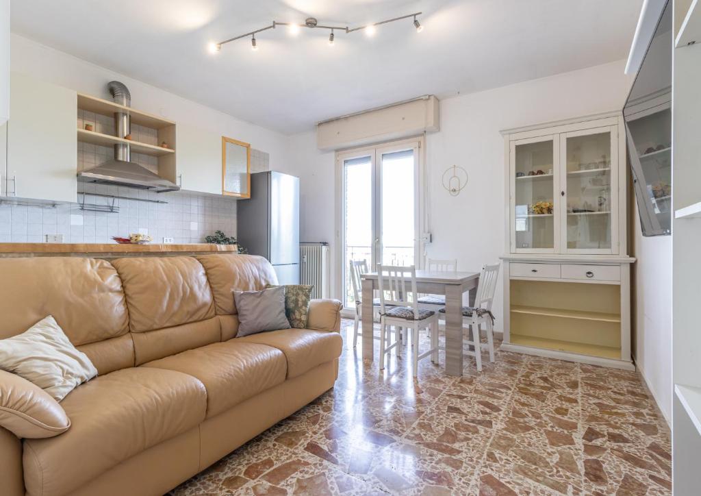 ein Wohnzimmer und eine Küche mit einem Sofa und einem Tisch in der Unterkunft Casa della Musica - Affitti Brevi Italia in Modena