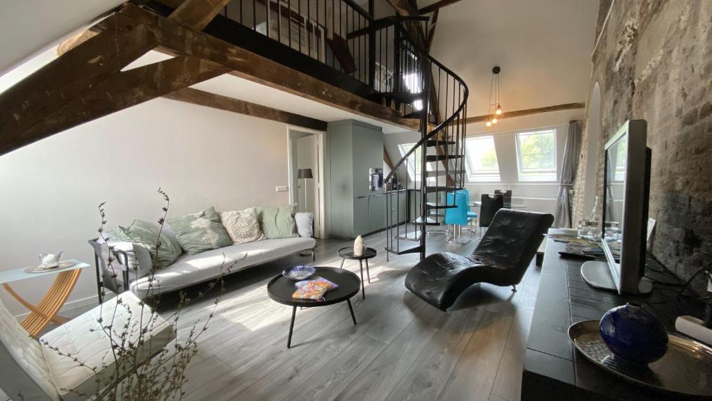 een woonkamer met een bank en een tafel bij Luxe en ruim appartement in Rijksmonument in Vianen