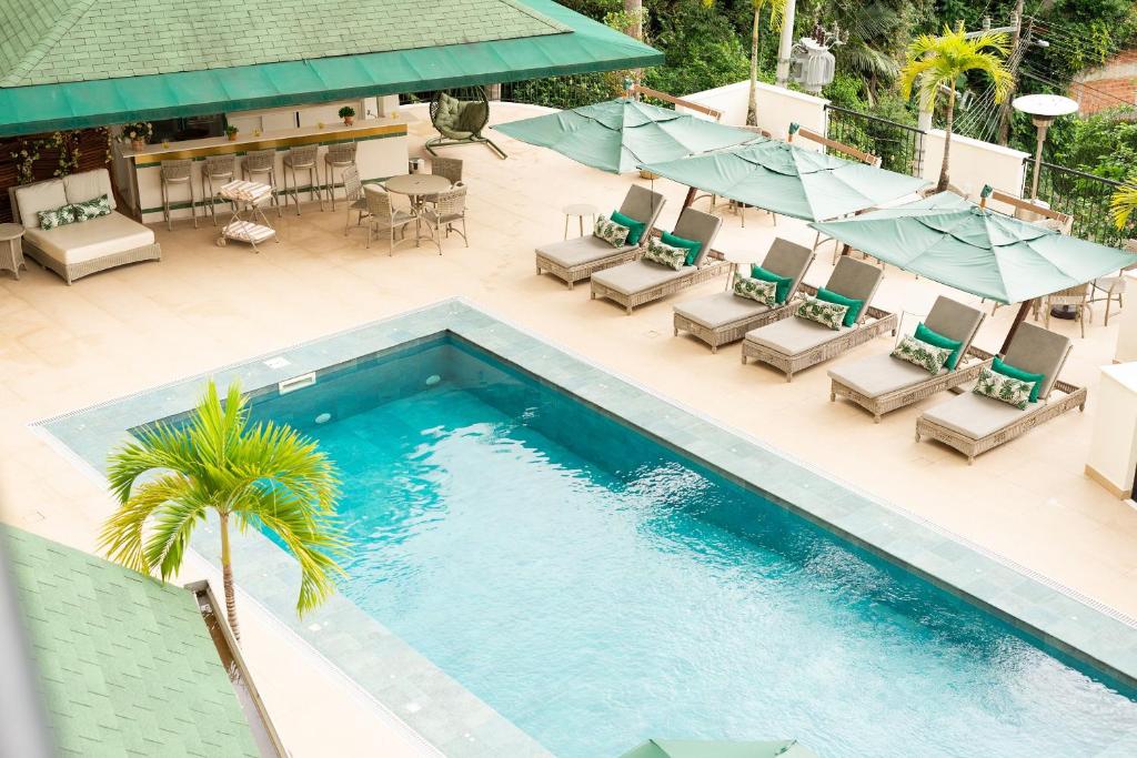 una vista aérea de una piscina con sillas y sombrillas en Villa do Vale Boutique Hotel, en Blumenau
