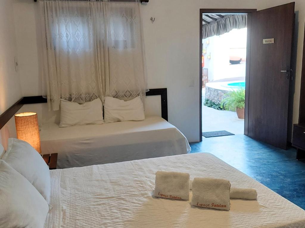 a bedroom with a bed with two towels on it at Espaço Fateixa in Jericoacoara