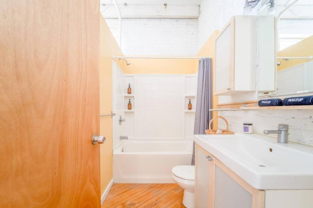 een badkamer met een wastafel, een toilet en een bad bij Cool Urban Stay Dtwn Apt And Patio in Binghamton