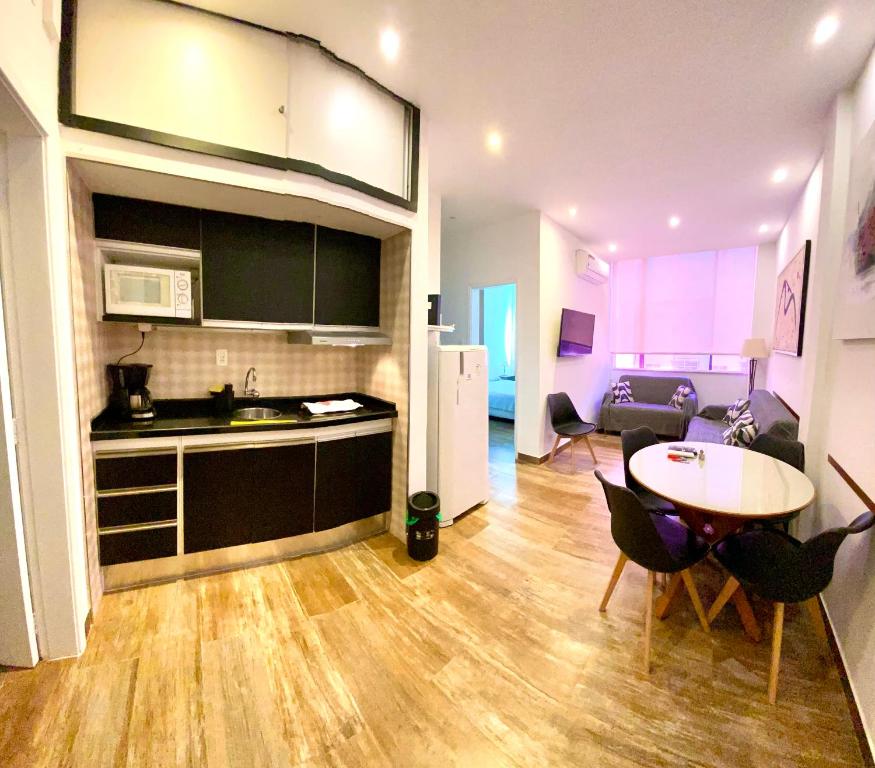 cocina y sala de estar con mesa y sillas. en Apartamento Xavier da Silveira 40, en Río de Janeiro