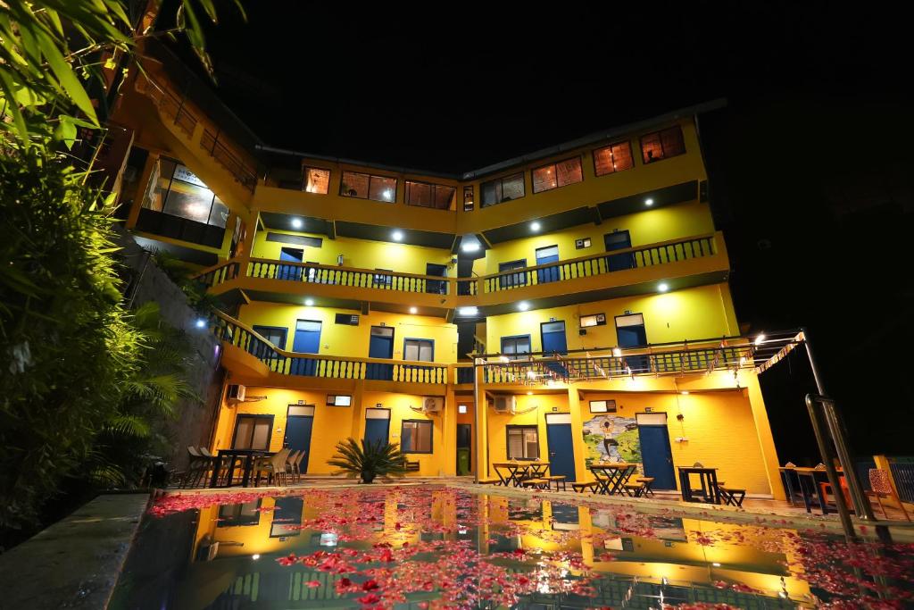 a building with a pool in front of it at night at Shalom Backpackers Rishikesh in Rishīkesh