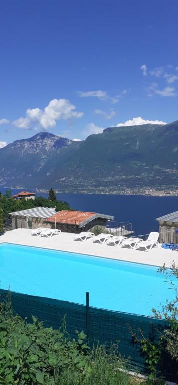 duży basen z krzesłami i wodą w obiekcie Maisonette Caterina w Tremosine Sul Garda