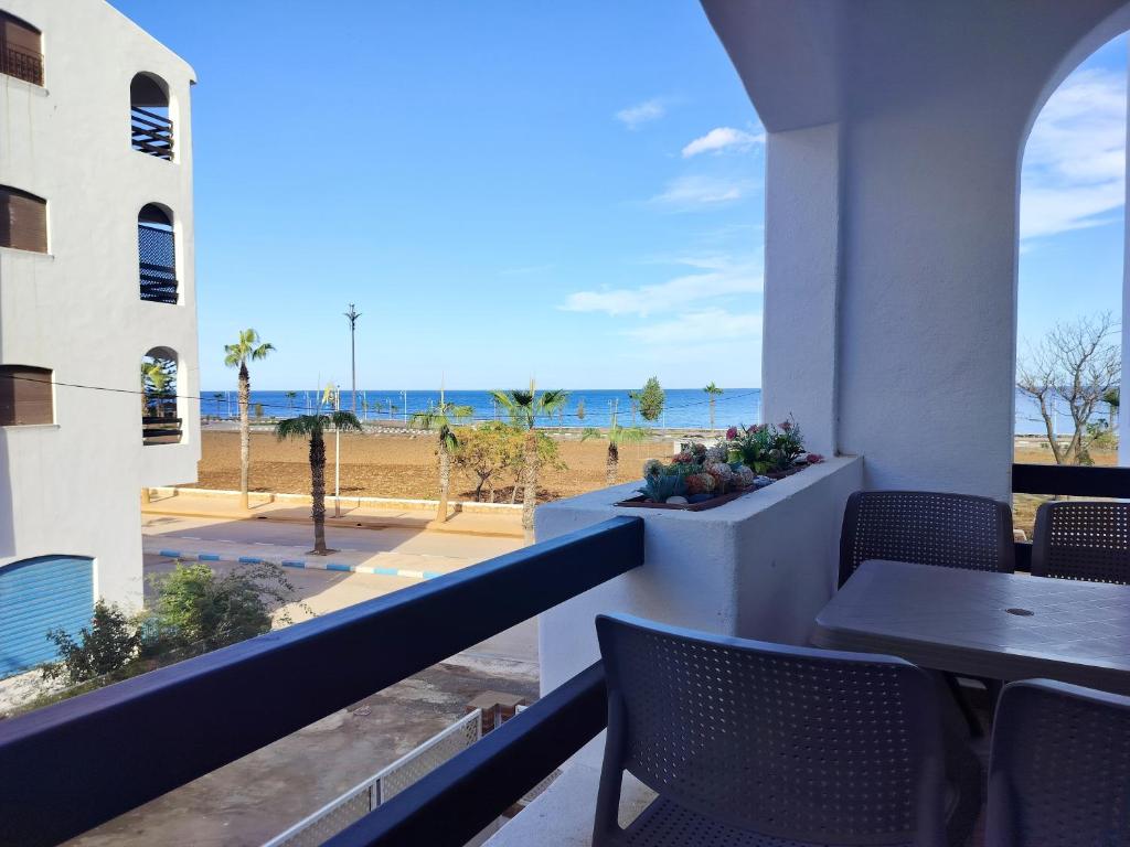 a balcony with a table and chairs and the beach at Oued laou beach in Oued Laou