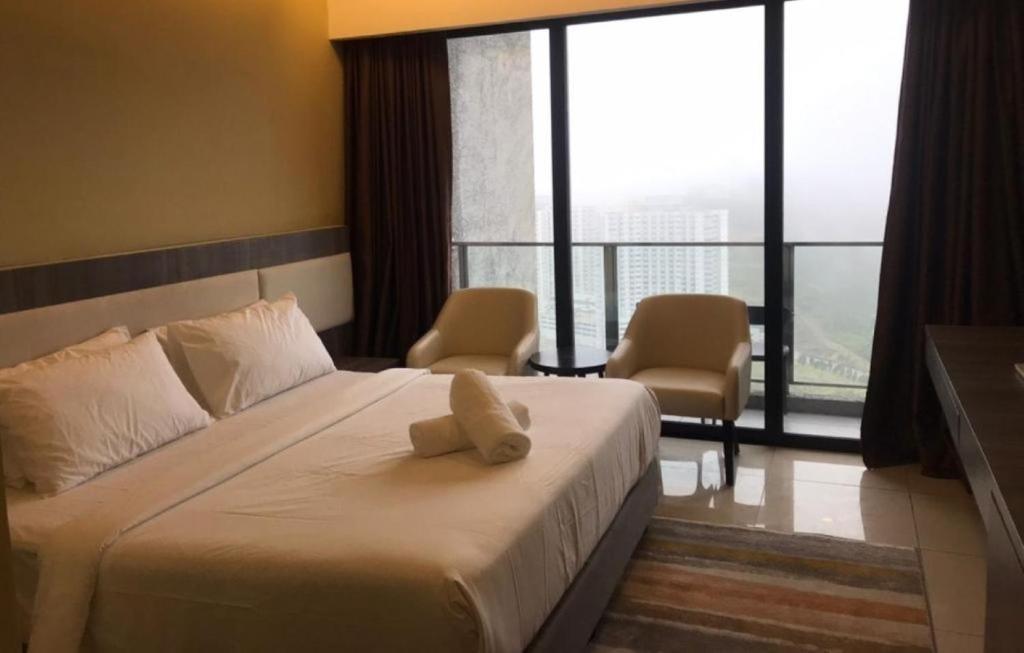 a hotel room with a bed with a towel on it at Genting Ion Delemen TopSky Holiday Suite & Studio Room in Genting Highlands