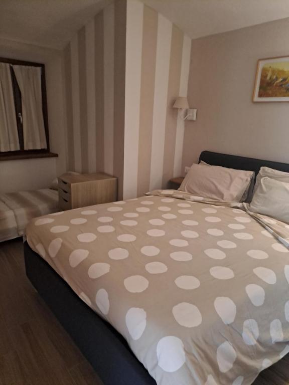 een slaapkamer met een groot bed met stippen erop bij La coccinella in Oulx