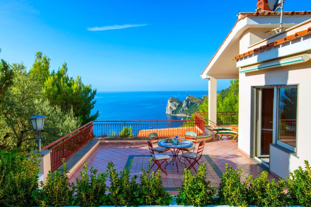 a patio with a table and chairs and the ocean at Christa Guest House in Massa Lubrense