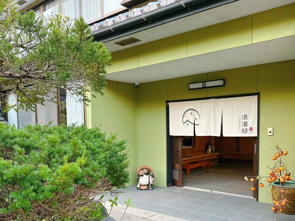 un perro sentado frente a un edificio con un escenario en 大正の宿　浪漫邸 en Kani