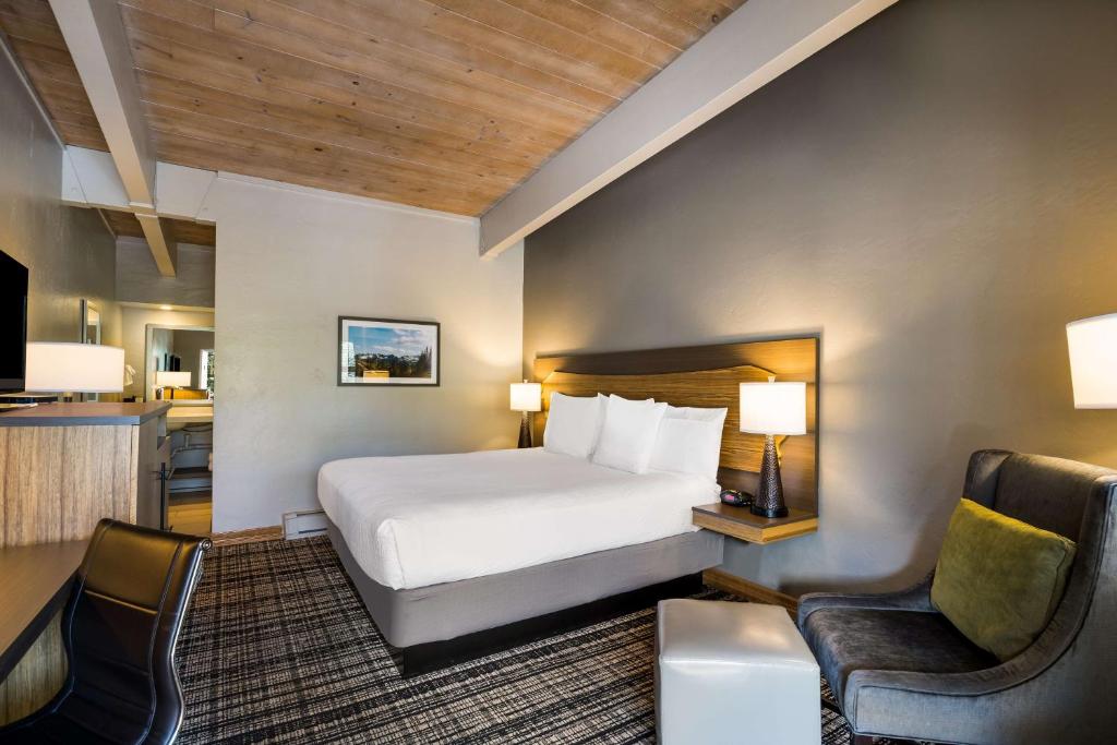 a hotel room with a bed and two chairs at Best Western Antlers at Glenwood Springs in Glenwood Springs