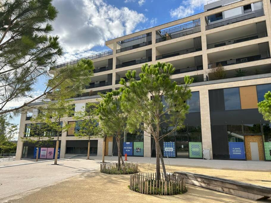 un grand bâtiment avec des arbres devant dans l'établissement Magnifique appartement T4, à Bordeaux