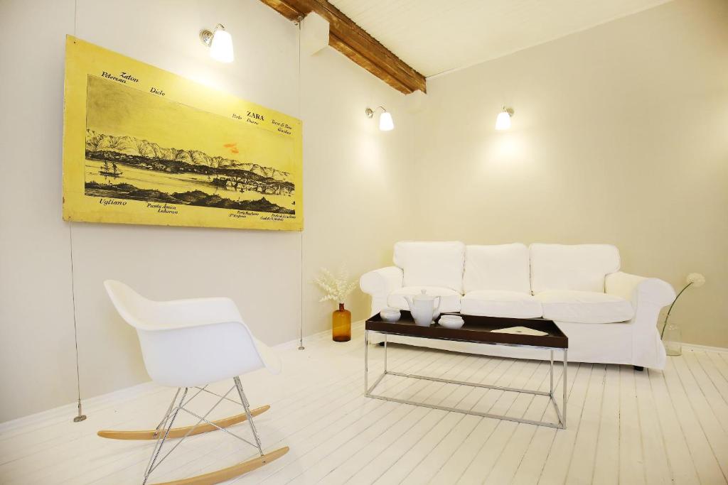 ein Wohnzimmer mit einer weißen Couch und einem Stuhl in der Unterkunft The Big Blue - old town center in Zadar