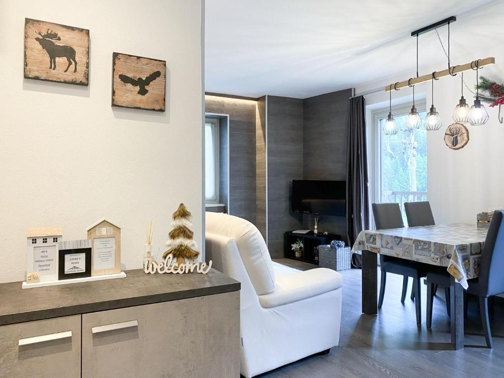 ein Wohnzimmer und ein Esszimmer mit einem Esstisch in der Unterkunft Angel's Home 2 in Ponte di Legno