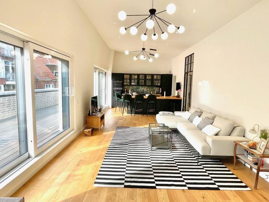 a living room with a white couch and a table at Barrierefr. Penthouse am Hafen mit Sonnen-Terrasse in Eckernförde