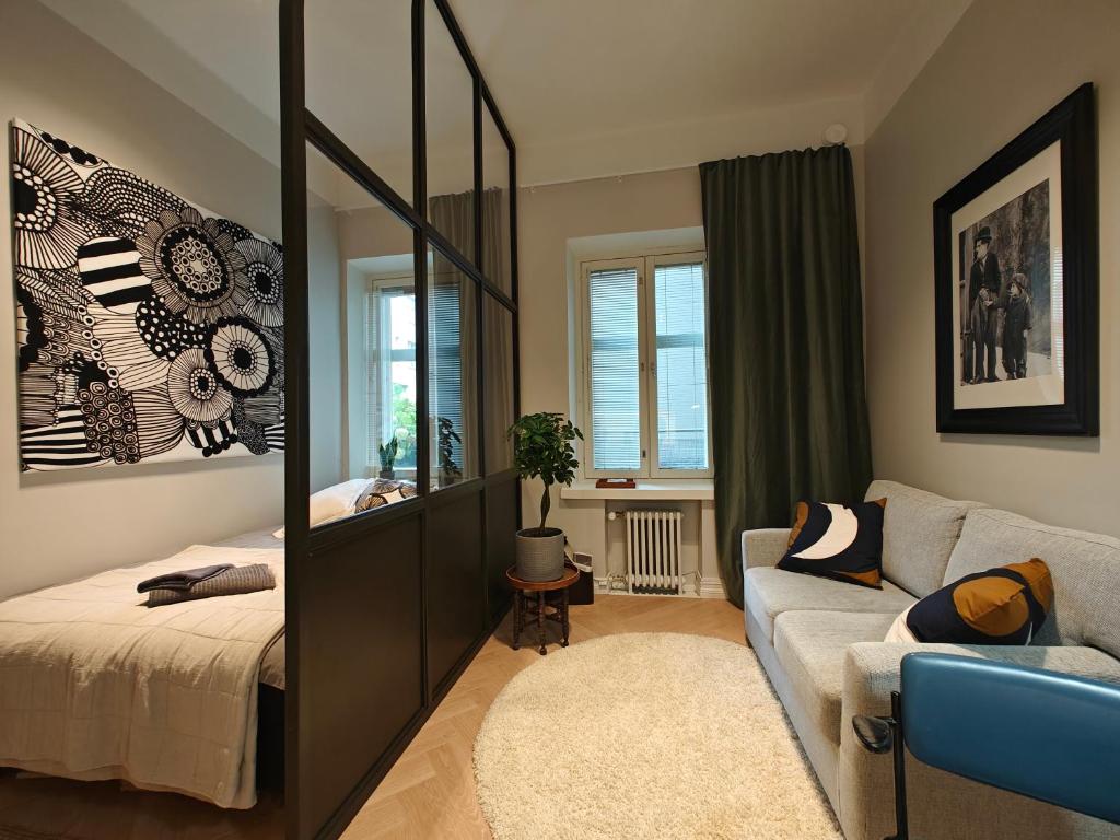 1 dormitorio con espejo, 1 cama y 1 sofá en Design studio in Kamppi en Helsinki