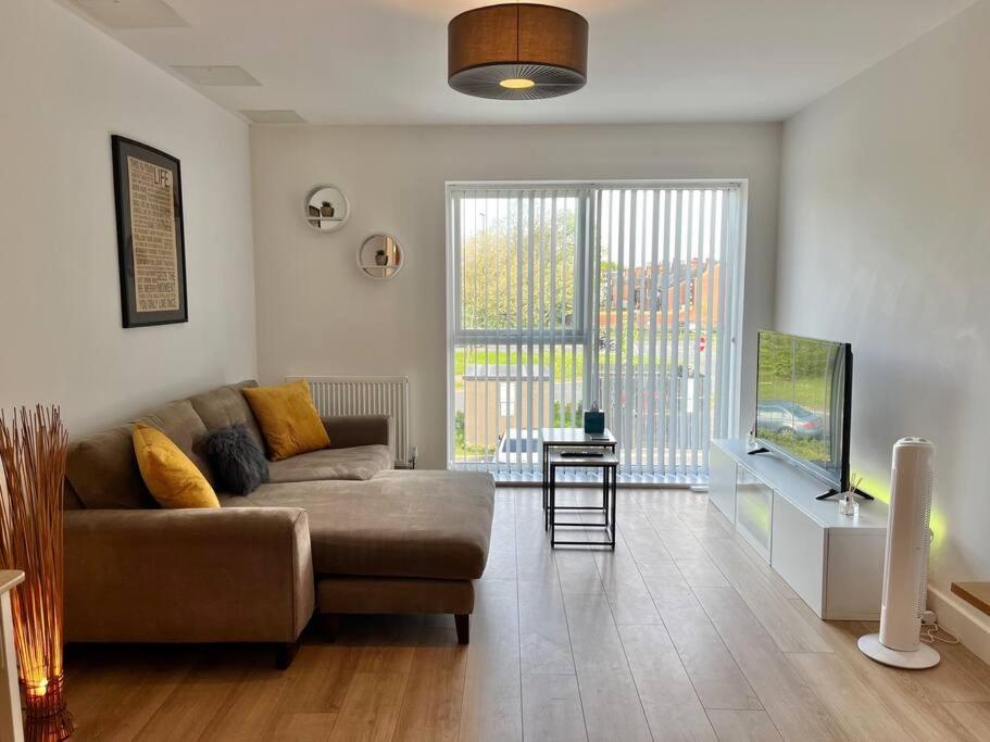 a living room with a couch and a television at Modern 1 Bedroom Serviced Apartment - Near City Centre in Doncaster