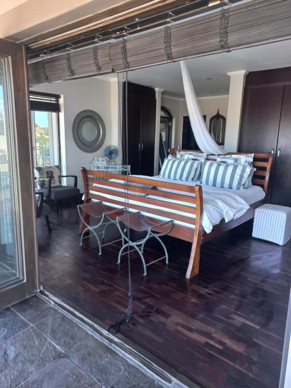 a bedroom with a large bed with blue and white pillows at Whale Rock Guest House in Plettenberg Bay